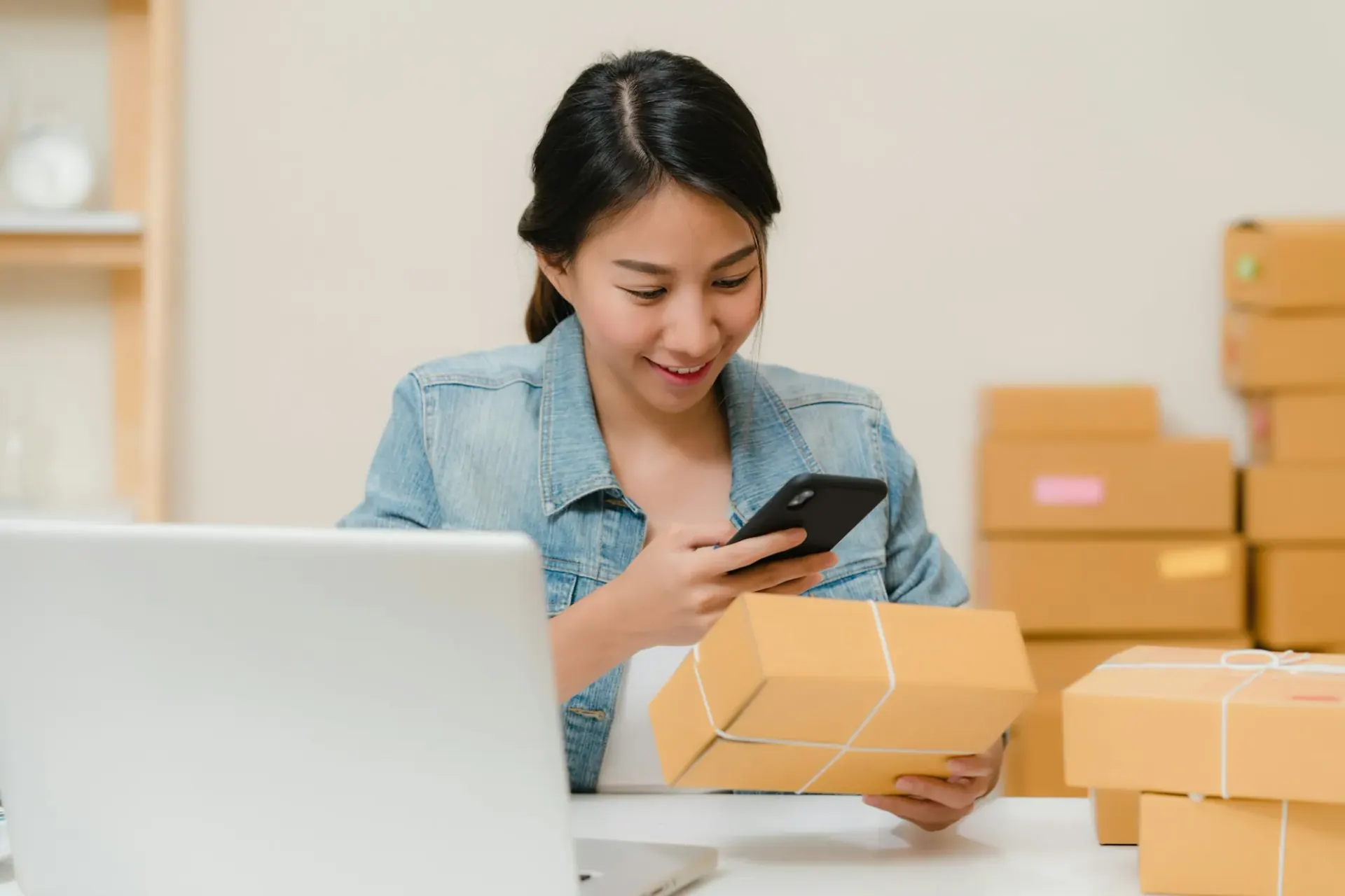 E-commerce brand owner checking an order beside her laptop